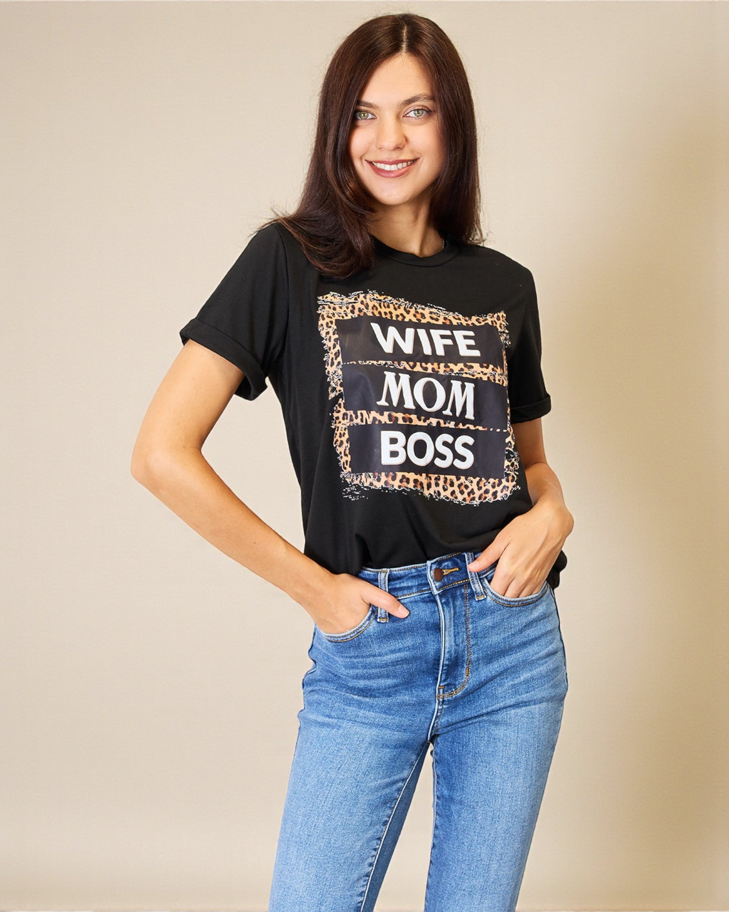 Woman wearing a black t-shirt with 'WIFE MOM BOSS' text and leopard print design.