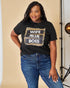 Woman wearing a black t-shirt with 'WIFE MOM BOSS' text and blue jeans on a beige background