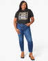 A woman modeling a black graphic t-shirt with a leopard print border and the words 'WIFE MOM BOSS' in white and gold, paired with blue jeans and brown ankle boots, against a light gray background.