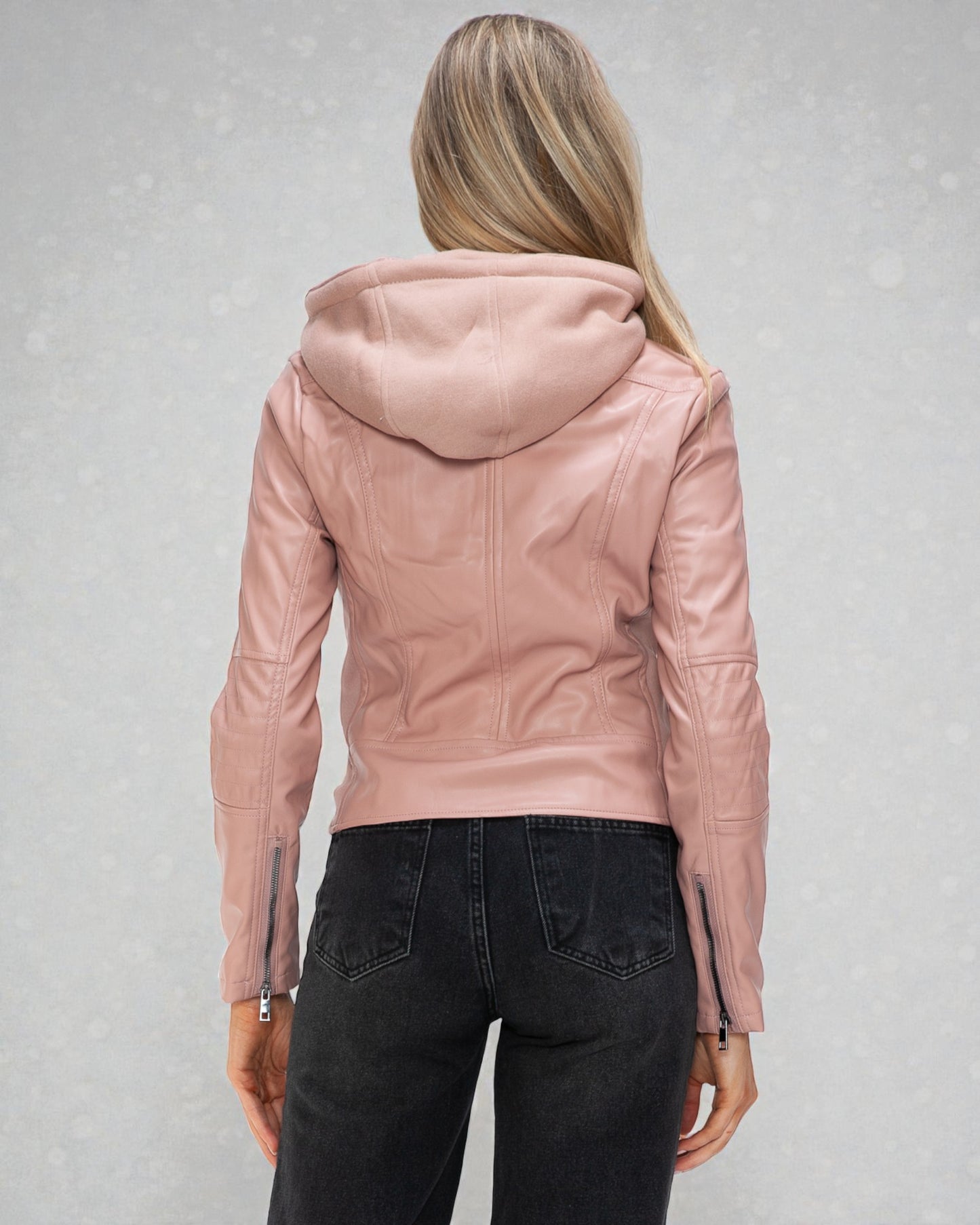 Person wearing a pink leather jacket on a gray background