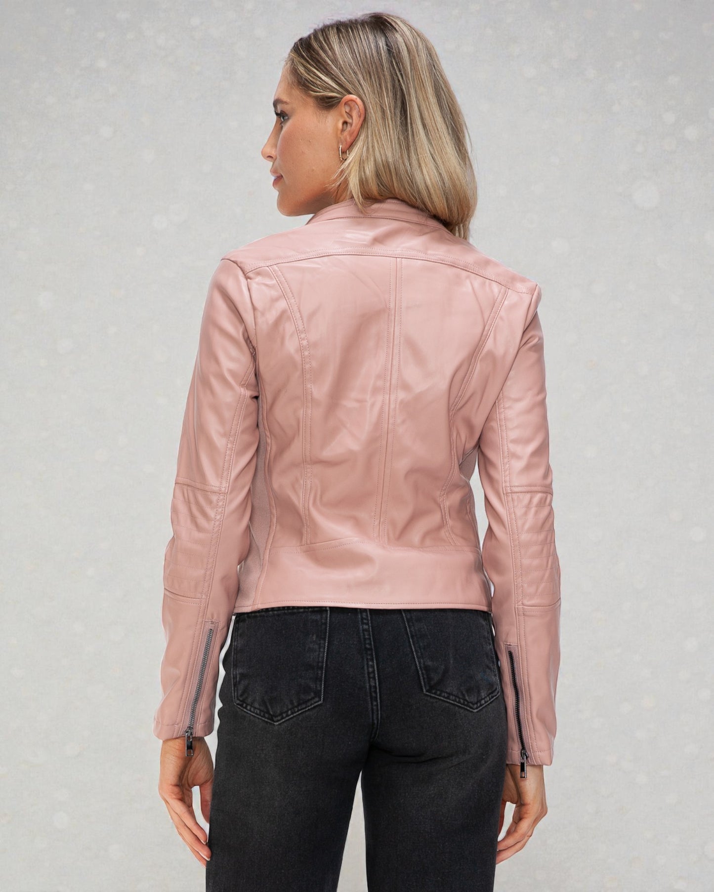 Person wearing a pink leather jacket on a light gray background