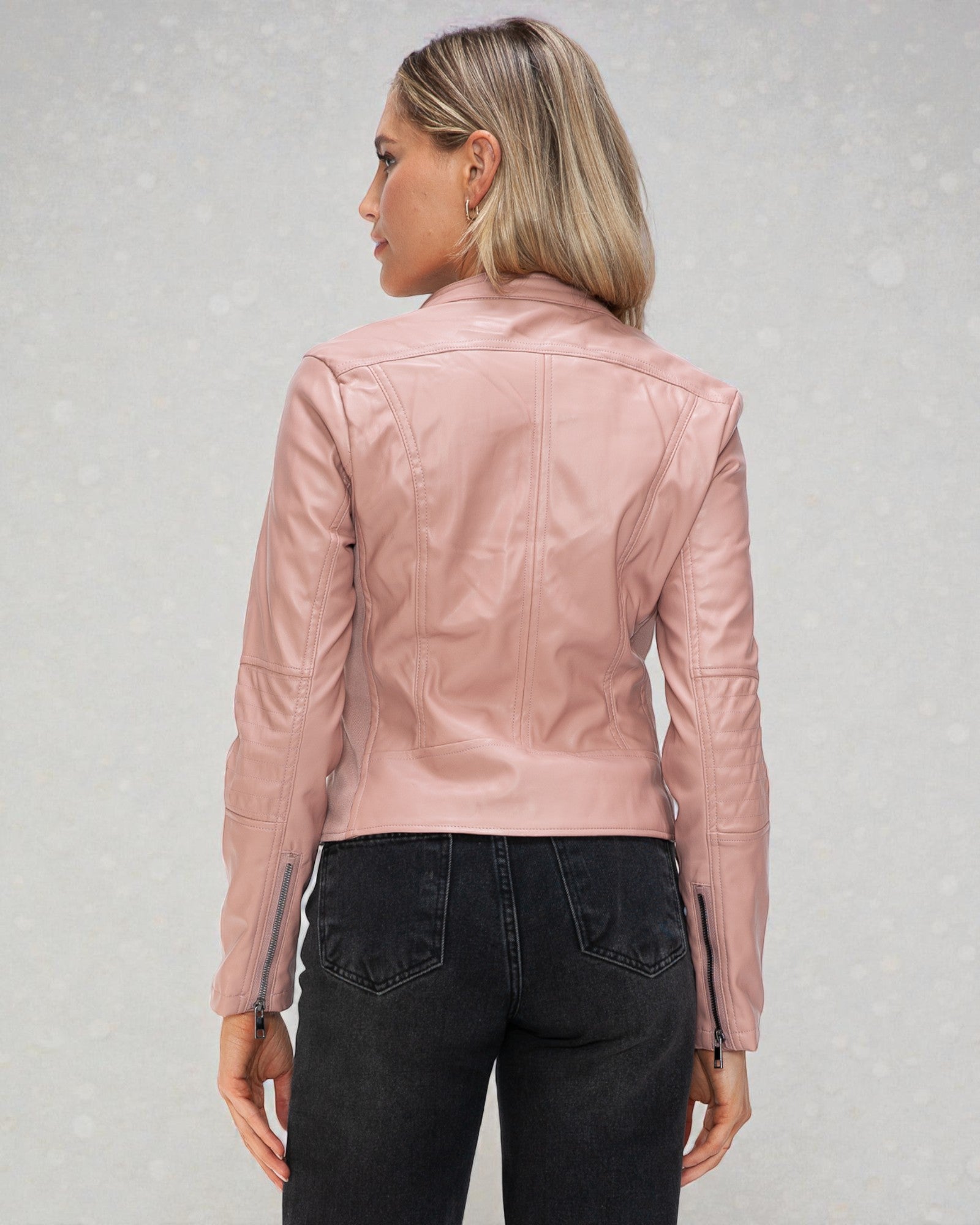 Person wearing a pink leather jacket on a light gray background