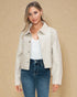Woman wearing a beige jacket over a white top and blue jeans on a beige background