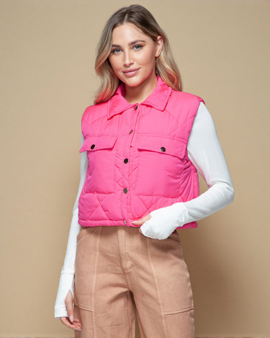 Woman wearing a pink puffer vest against a beige background