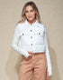 Woman wearing a white puffer vest over a long-sleeve shirt with beige pants against a beige background