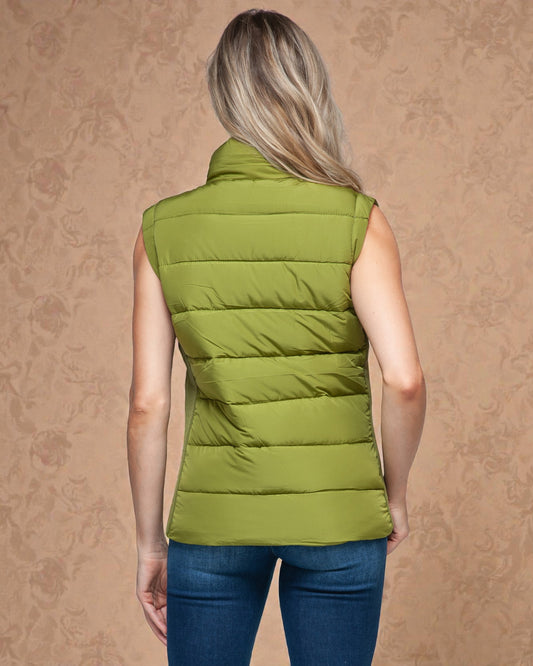 Person wearing a green puffer vest on a beige background