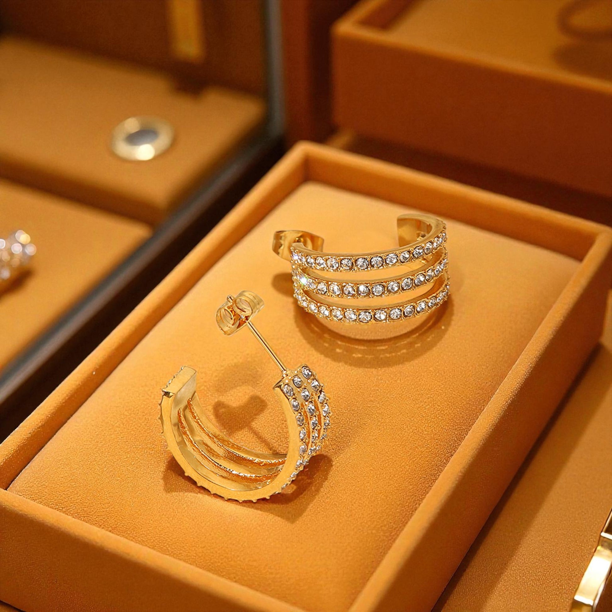 Gold jewelry set with earrings and rings on a brown display box