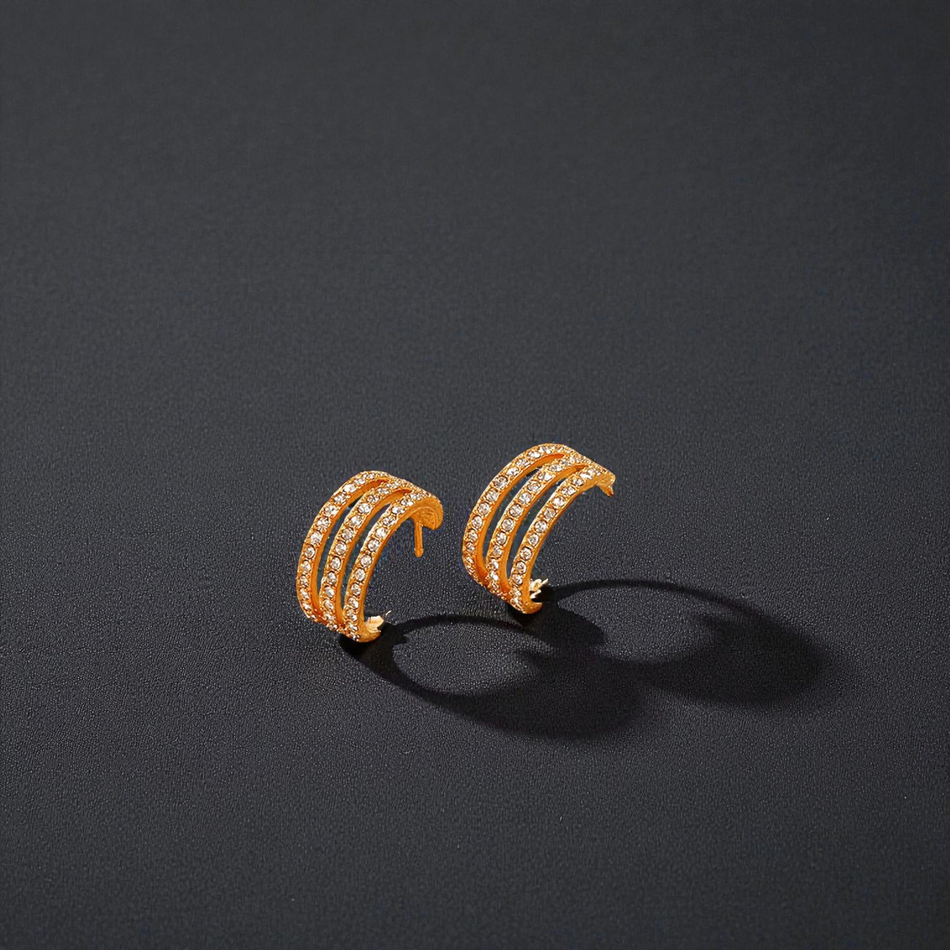 Pair of gold hoop earrings on a dark gray background