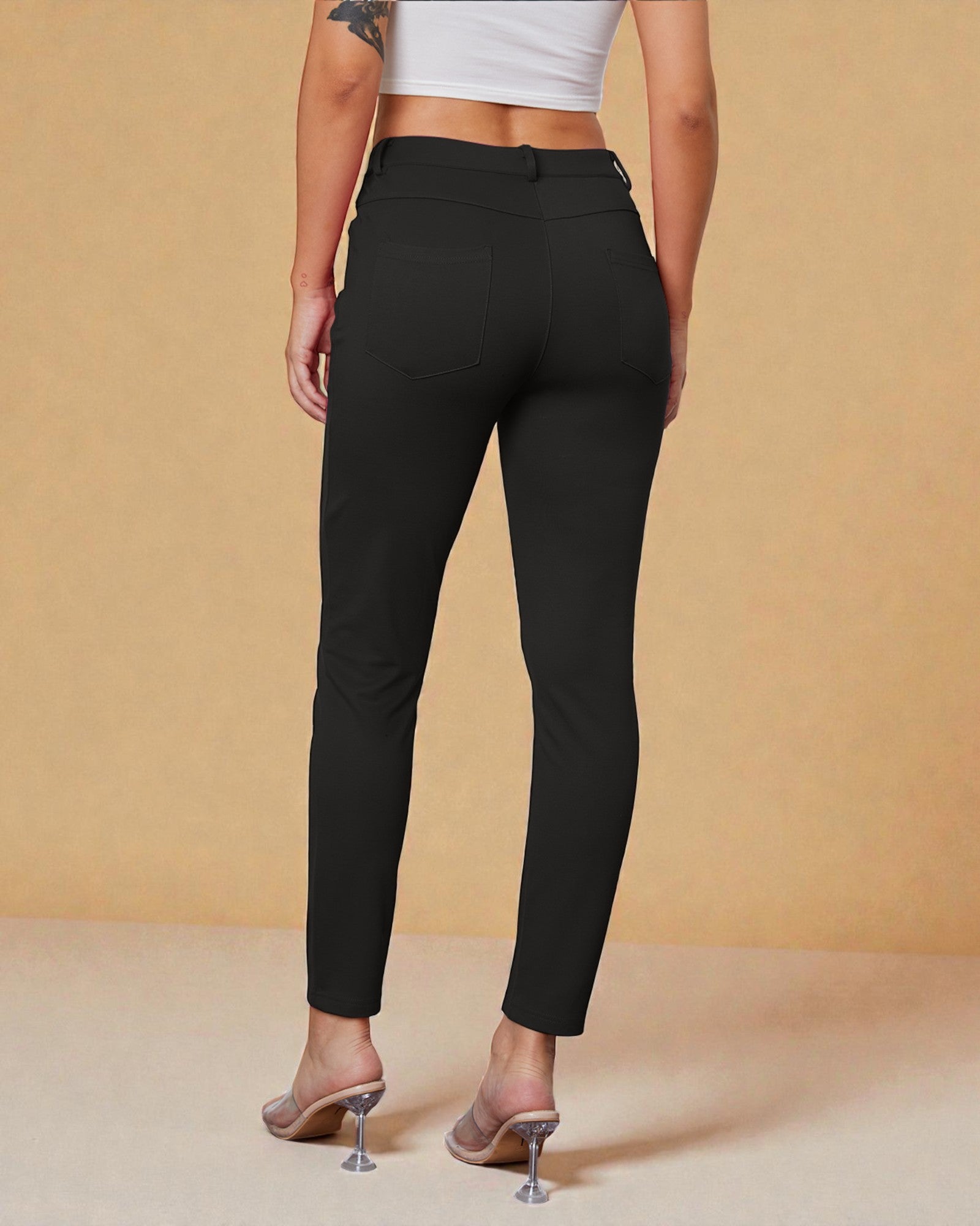 Person wearing black pants on a beige background