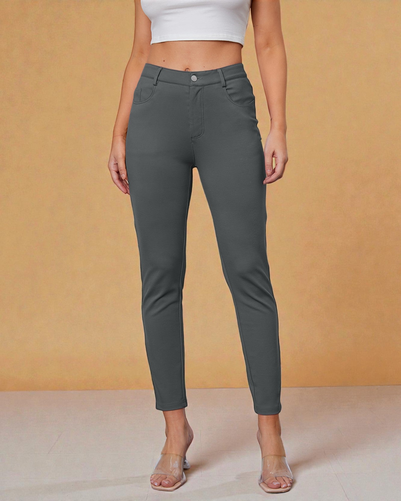 Person wearing gray pants against a beige background