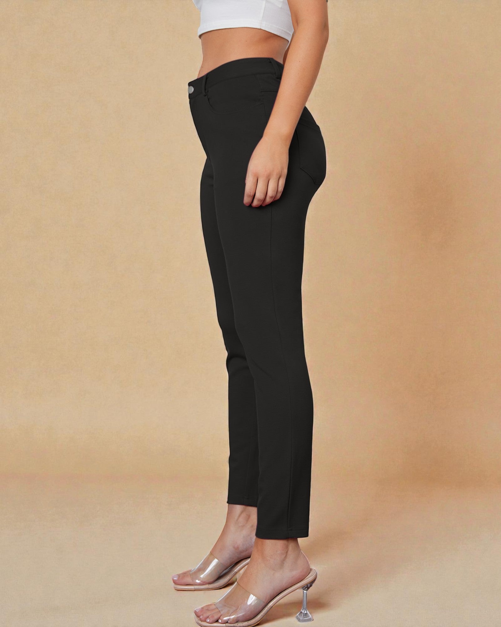 Black pants worn by a person on a beige background