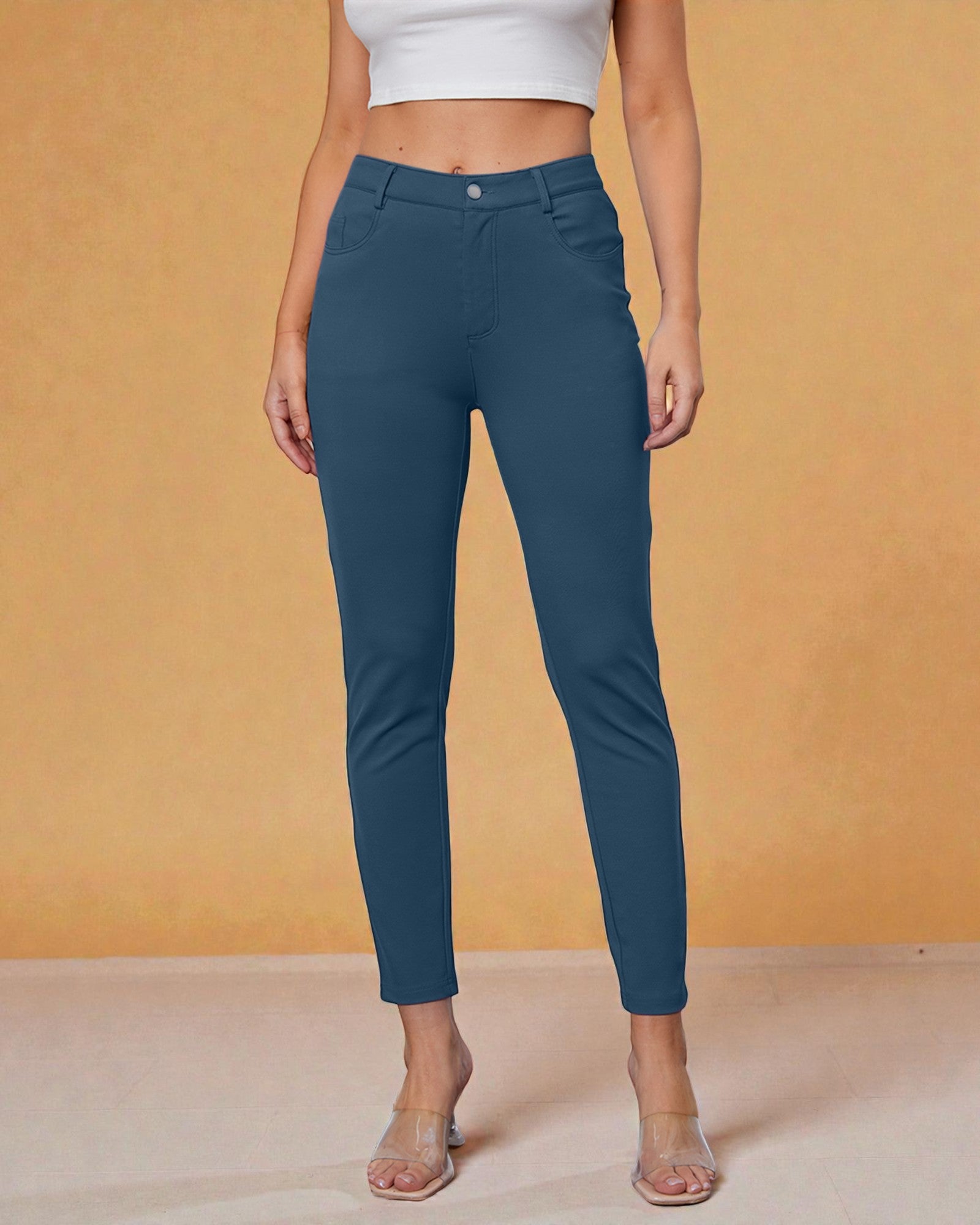 Person wearing teal pants against an orange background