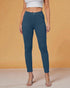 Person wearing teal pants against an orange background