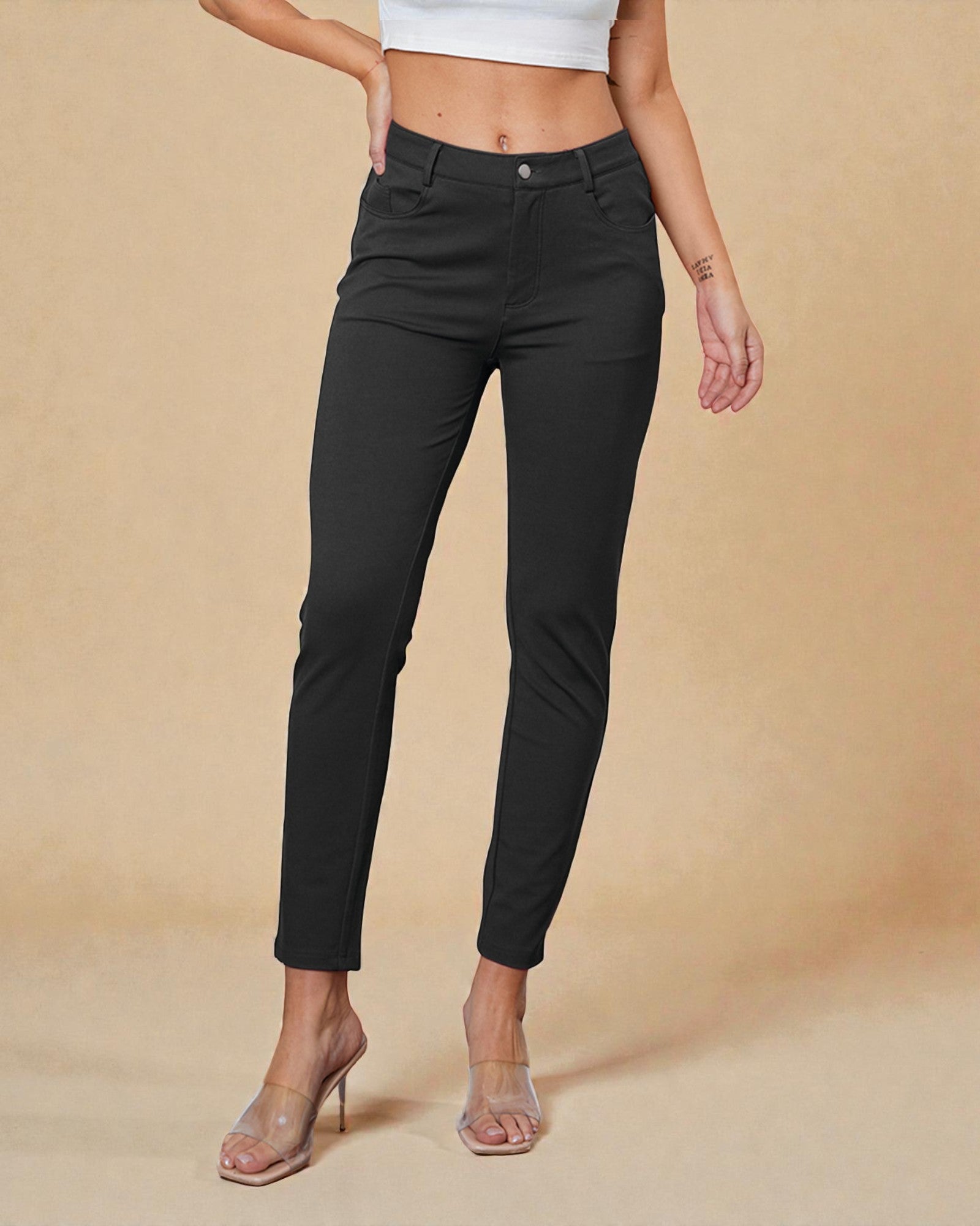 Person wearing black pants on a beige background