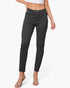 A model wearing a pair of dark charcoal gray slim-fit ankle-length jeans, styled with a white crop top and clear heeled sandals against a light gray studio background.