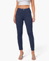 A model wearing a pair of navy blue slim-fit ankle-length pants, paired with a white crop top and clear high-heeled sandals, against a light gray studio background.