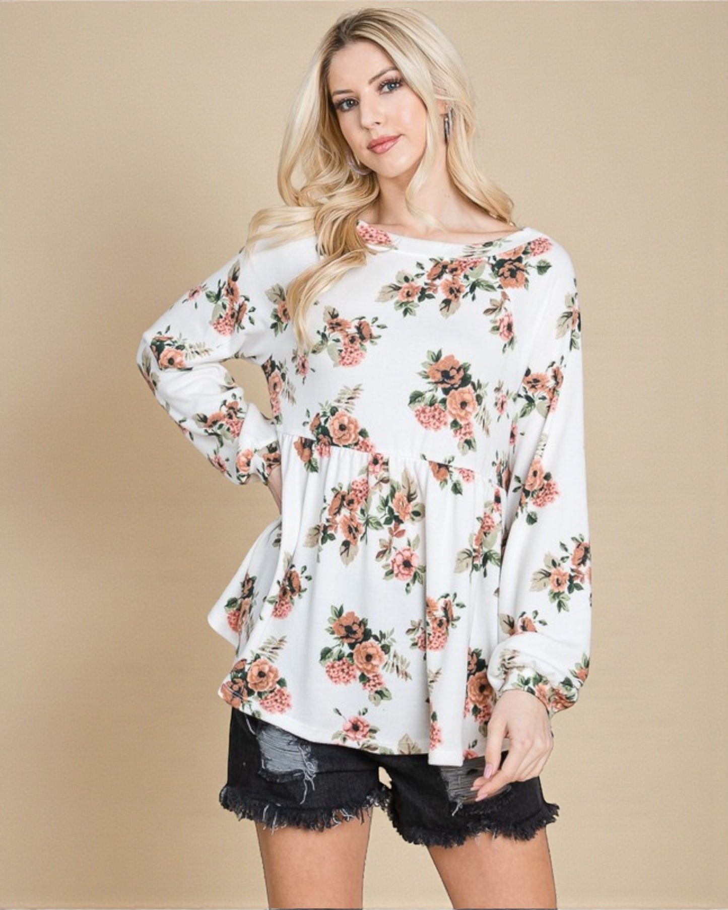 Woman wearing a white floral long-sleeve top against a beige background