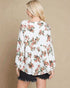 Woman wearing a floral blouse with a beige background