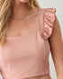 Pink top with ruffled shoulder detail on a plain background