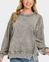 Woman wearing a gray sweatshirt with a plain background
