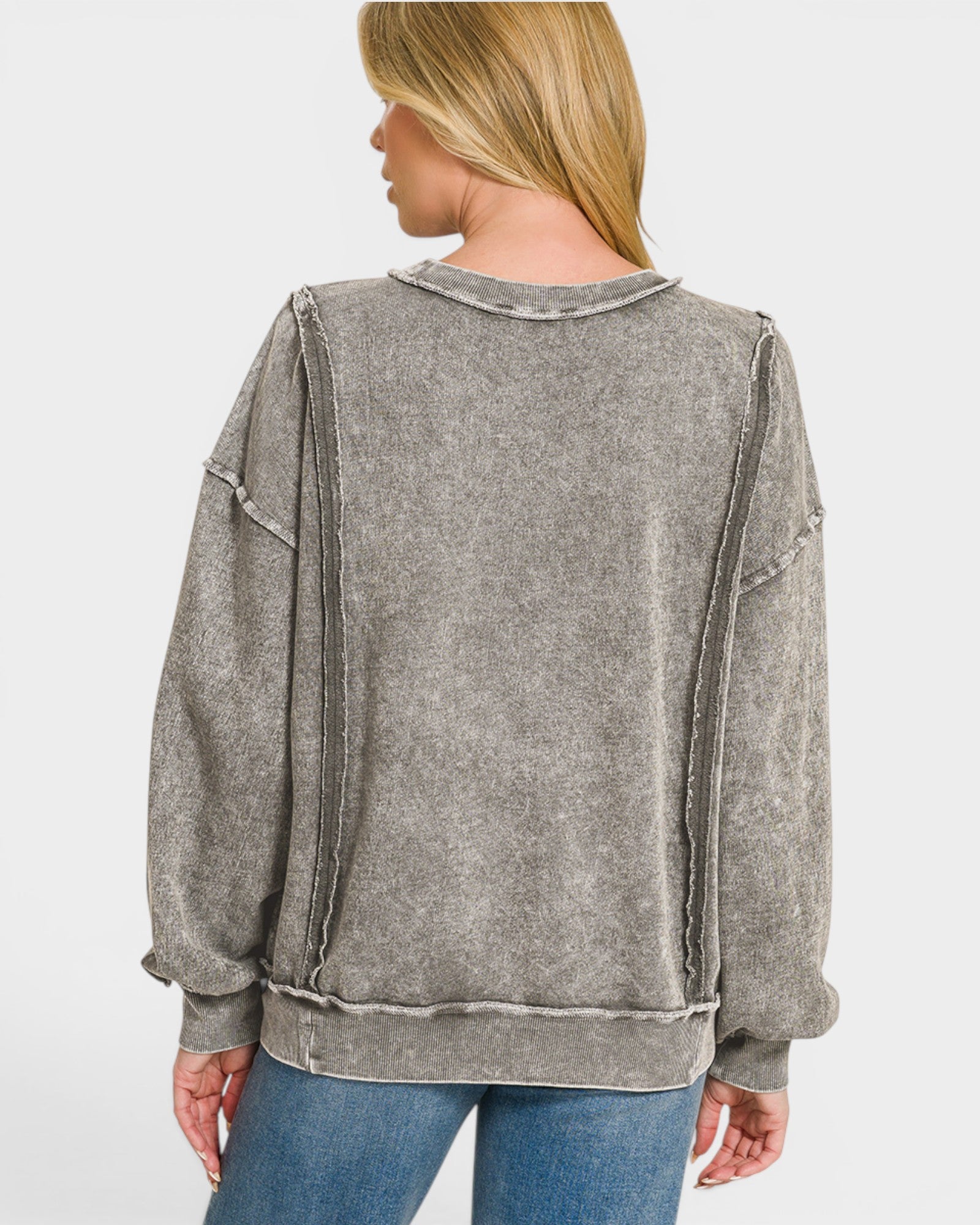 Person wearing a gray distressed jacket on a white background