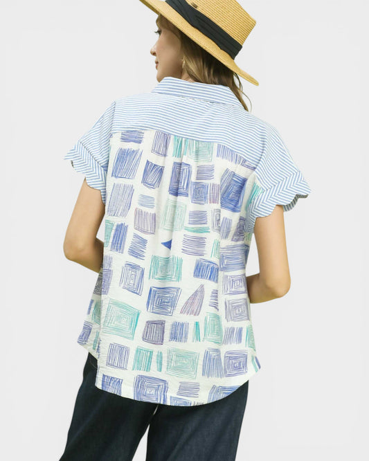 Woman wearing a patterned shirt with a plain background