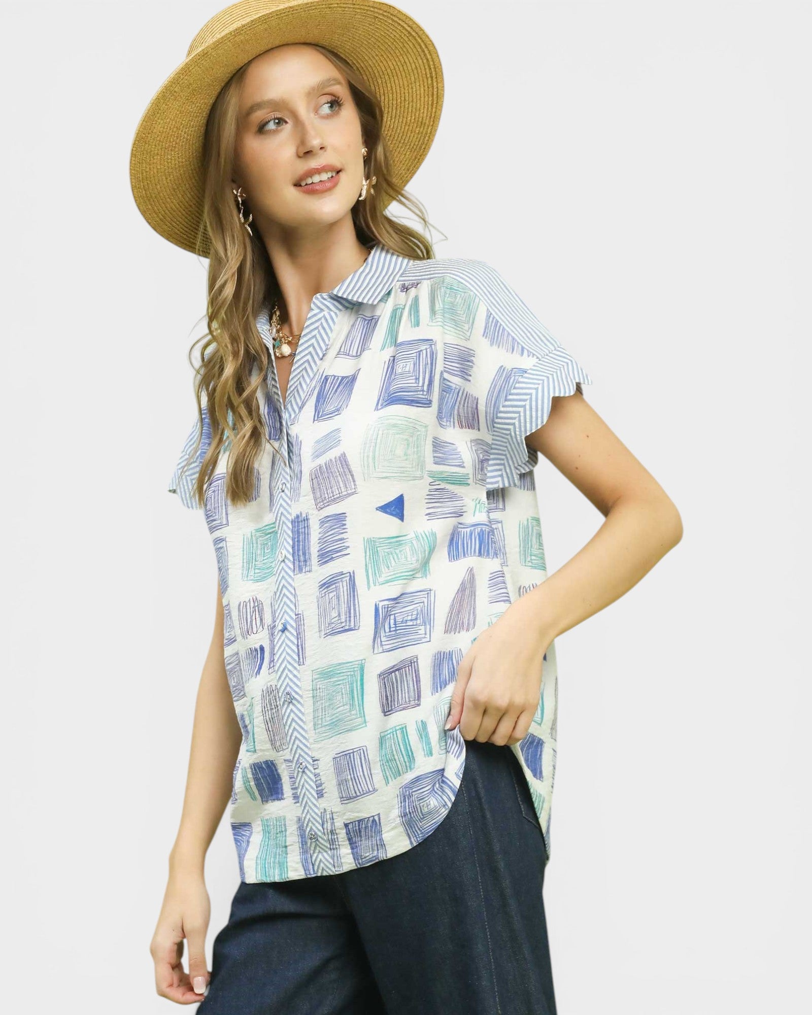 Woman wearing a patterned shirt and straw hat on a plain background