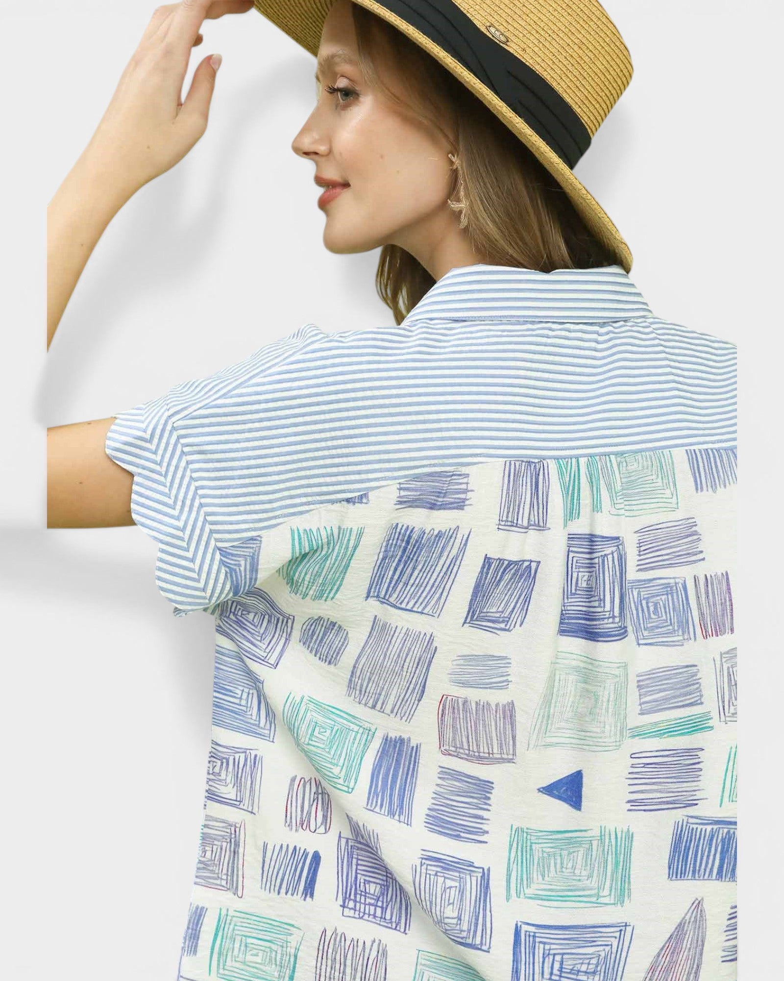 Woman wearing a striped shirt with a geometric patterned towel draped over her shoulder against a white background