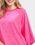 Close-up of a person wearing a bright pink textured top on a white background