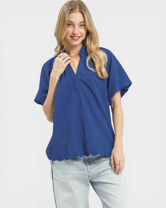 Woman wearing a blue top and light jeans on a white background