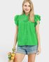 Woman wearing a green blouse with ruffled sleeves on a white background