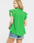 Woman wearing a green blouse with ruffled sleeves on a white background