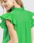 Green blouse with ruffled sleeves worn by a person on a white background
