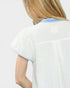 White blouse with blue trim on a plain background