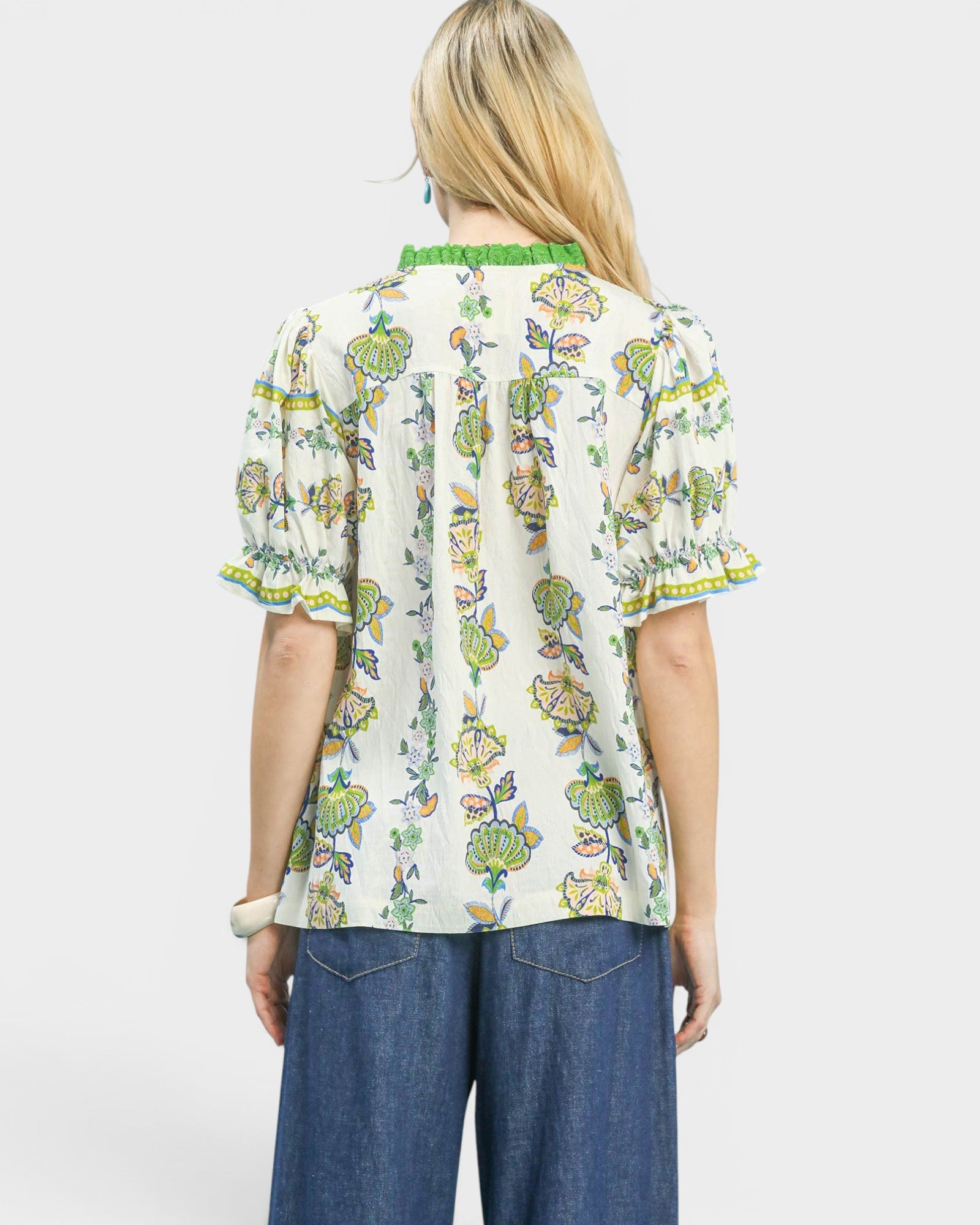 Woman wearing a floral blouse with a plain background