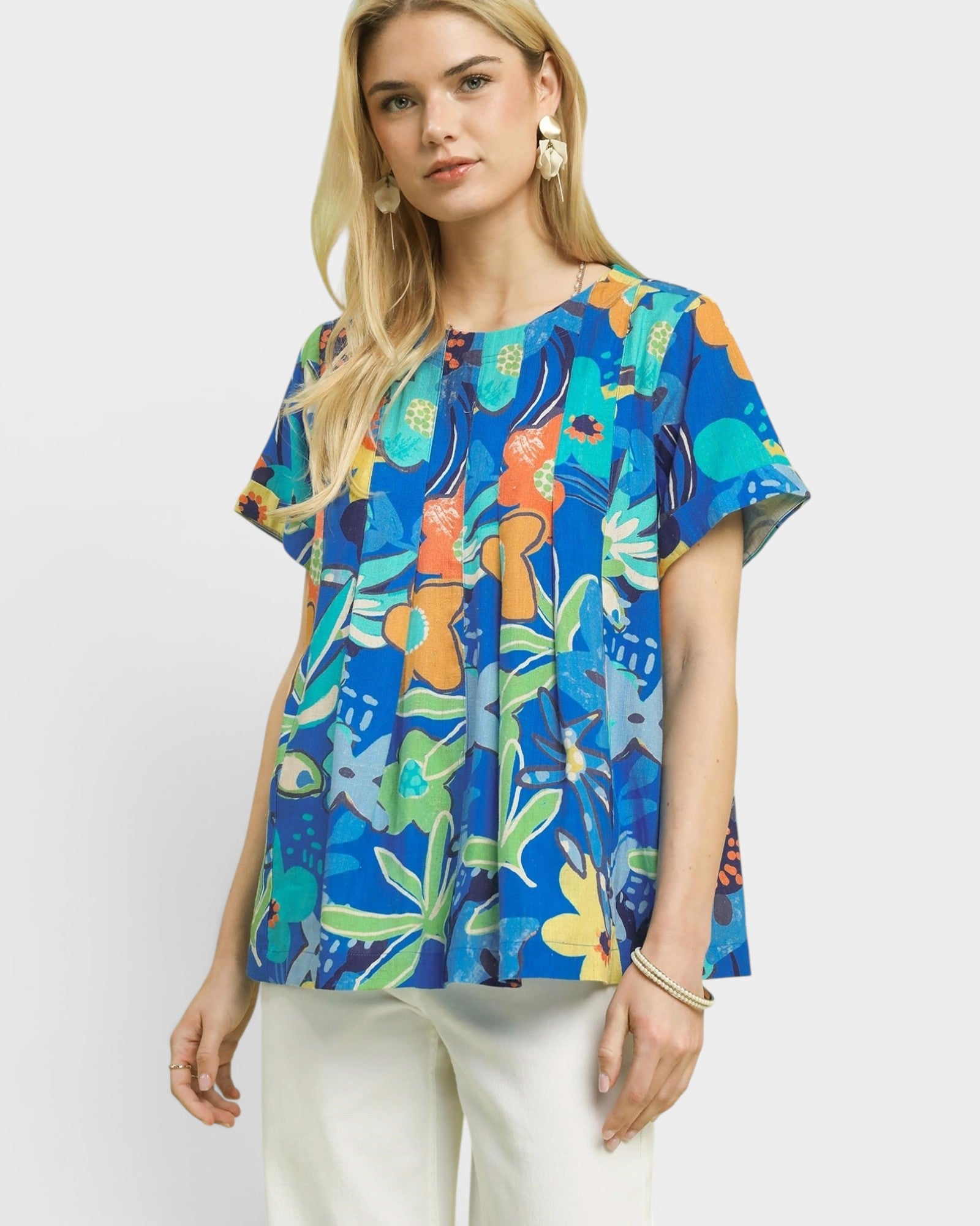 Woman wearing a colorful floral blouse against a white background