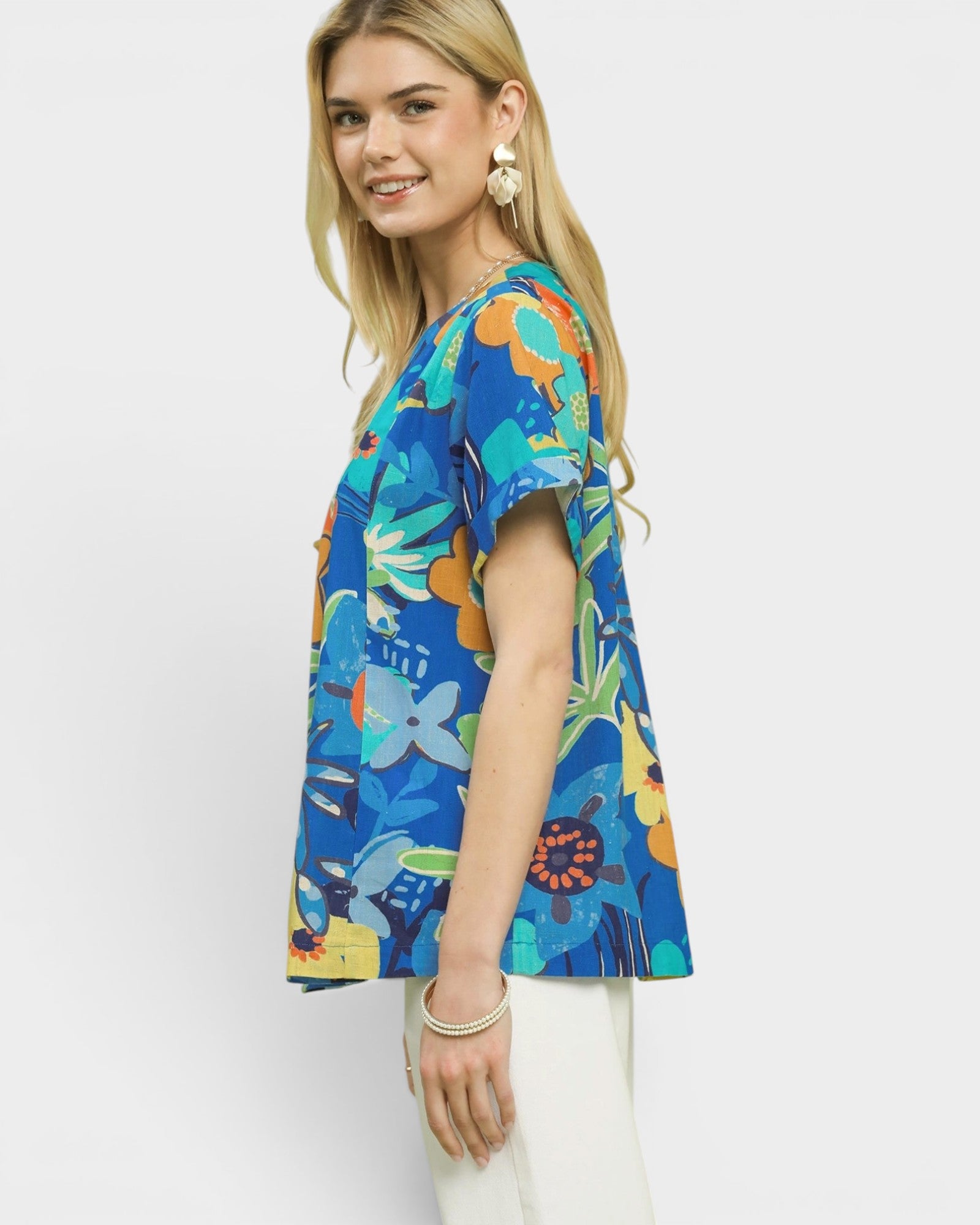 Woman wearing a colorful floral blouse on a white background