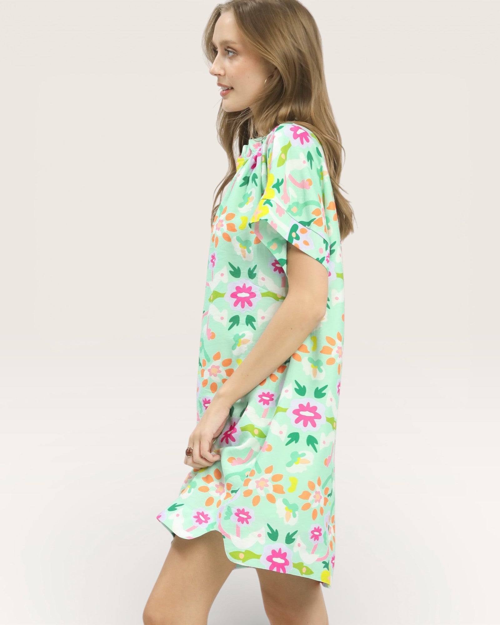 Young girl wearing a floral dress on a plain background