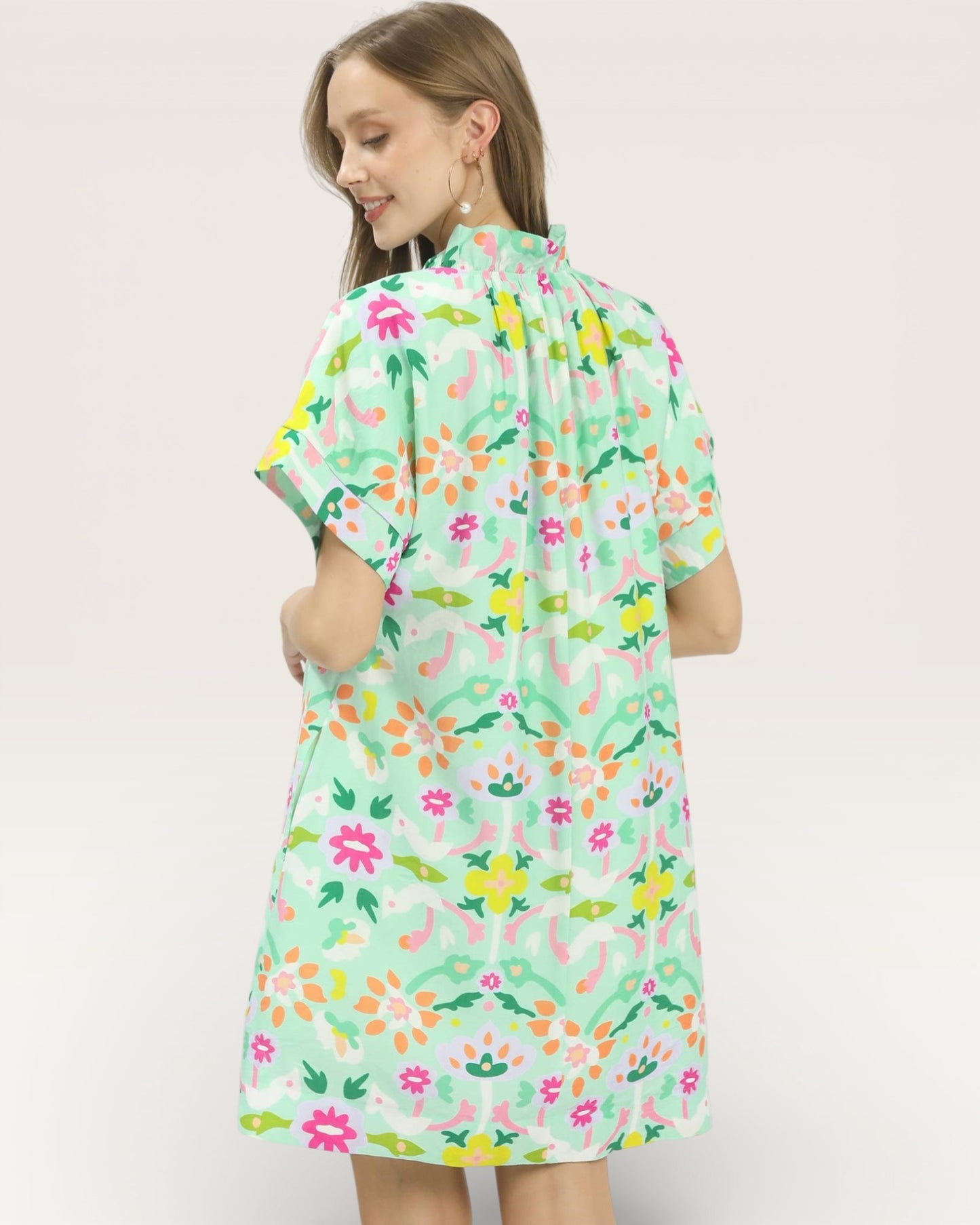 Woman wearing a floral dress with a plain background