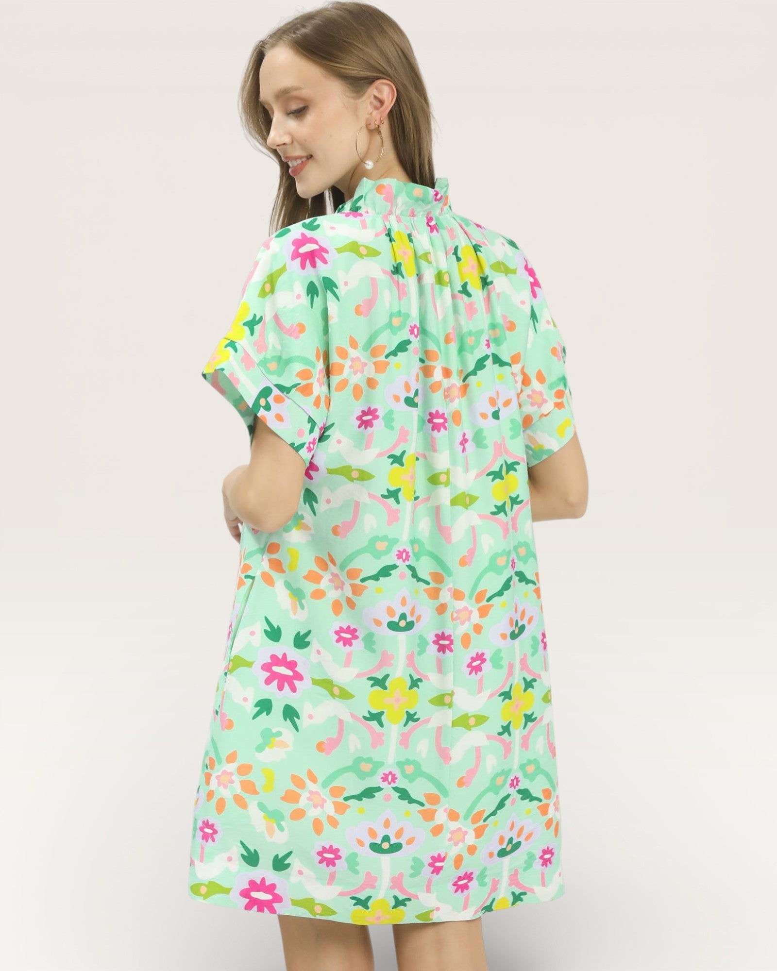 Woman wearing a floral dress with a plain background