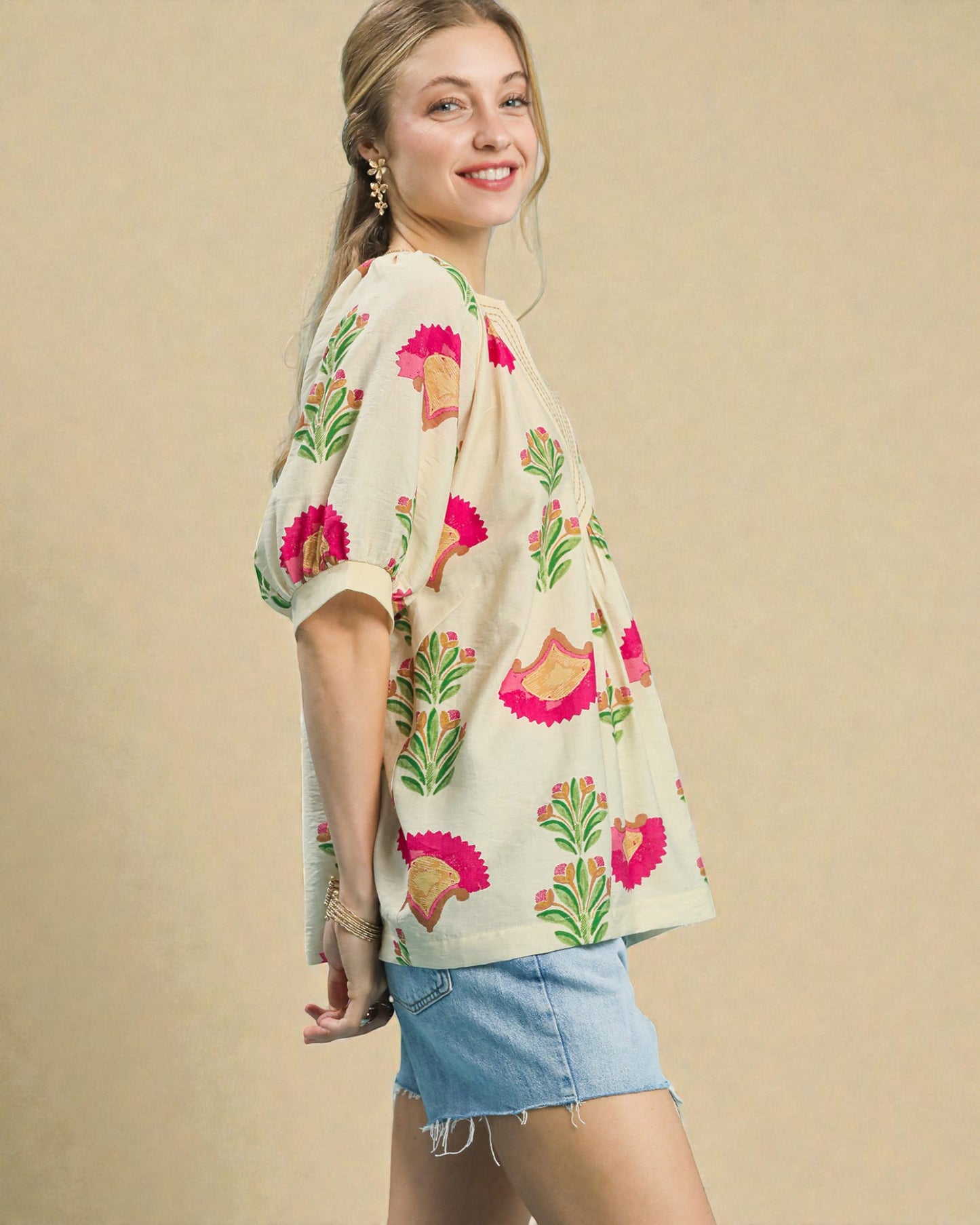 Woman wearing a floral kimono-style top with a beige background