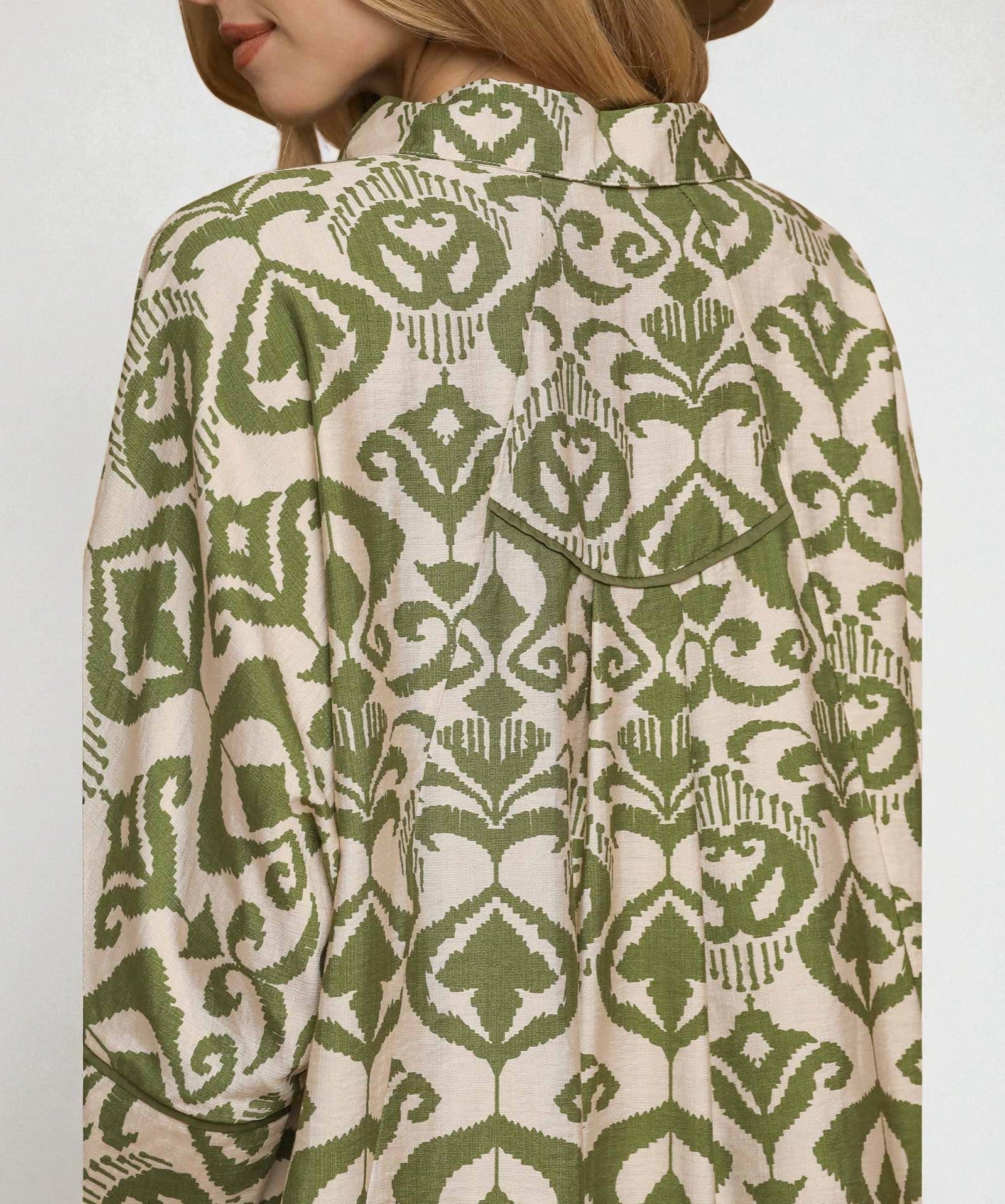 Green and beige patterned shirt on a plain background