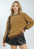 Woman wearing a patterned sweater and black leather shorts on a white background