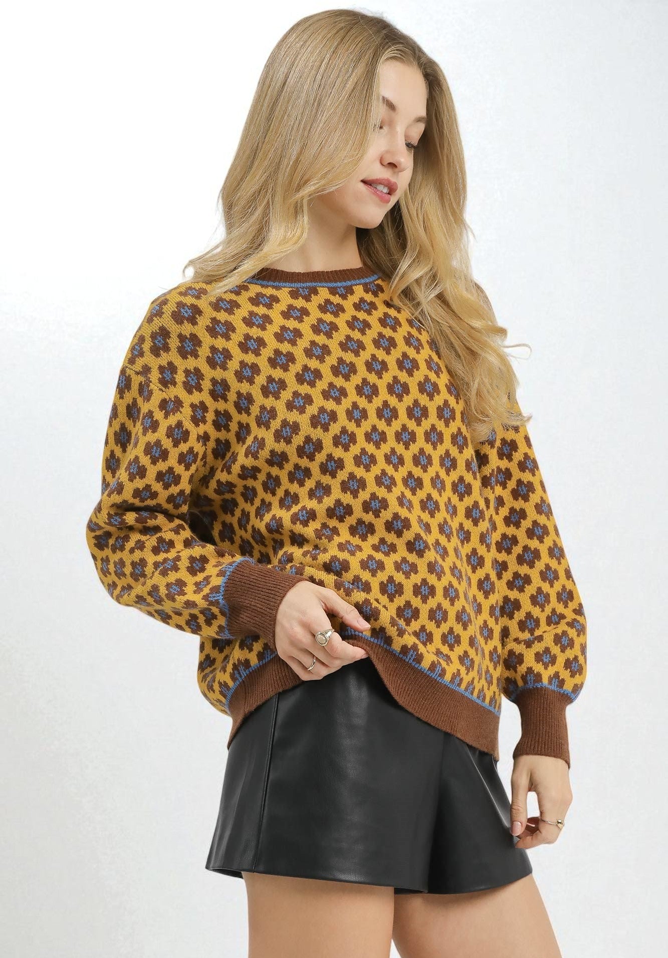 Woman wearing a patterned sweater and black skirt on a white background