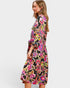 Woman wearing a colorful floral dress on a white background