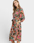 Woman wearing a colorful floral dress on a white background