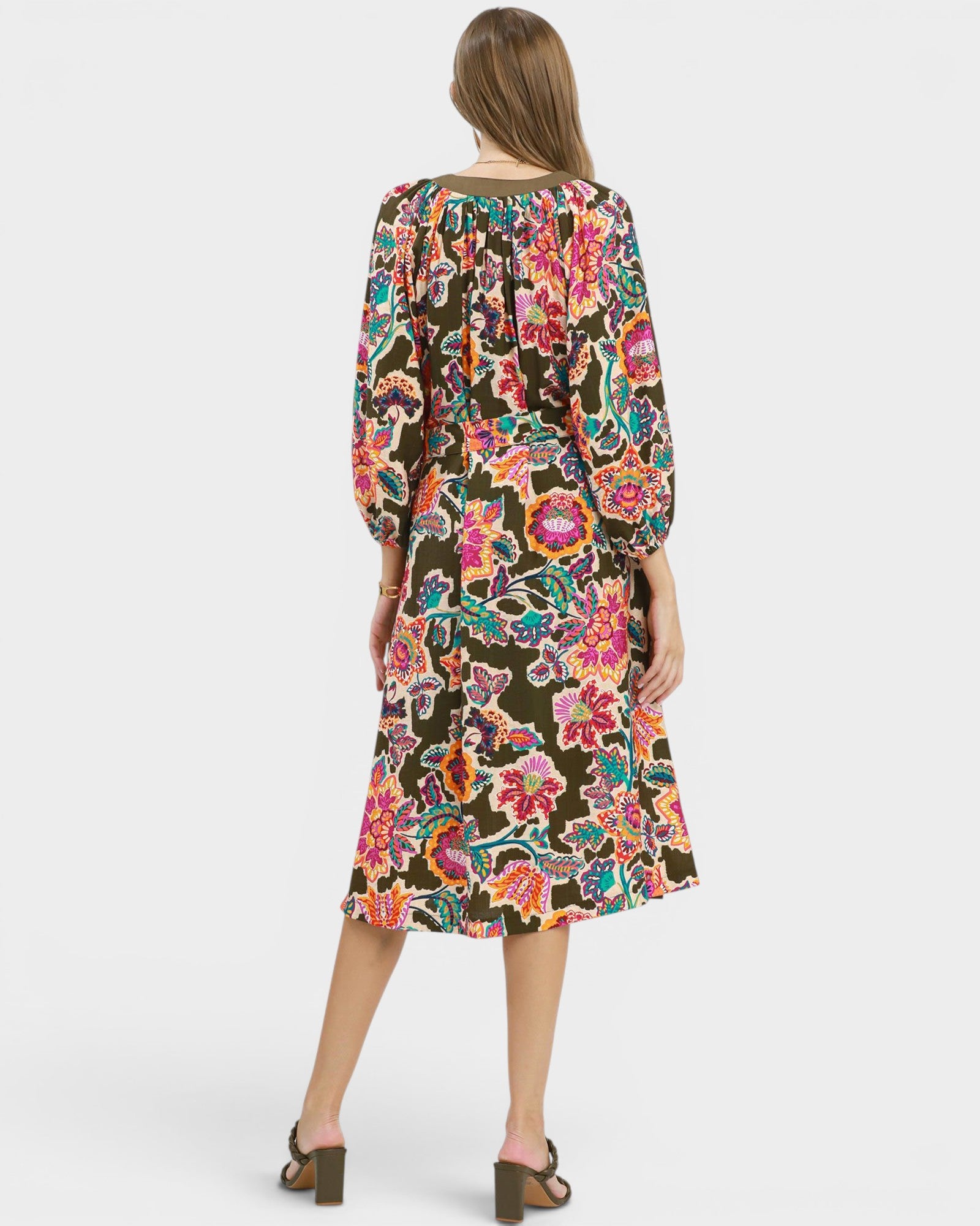 Woman wearing a colorful floral dress on a white background