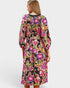 Woman wearing a colorful floral dress on a white background