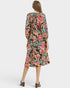 Woman wearing a colorful floral dress on a white background