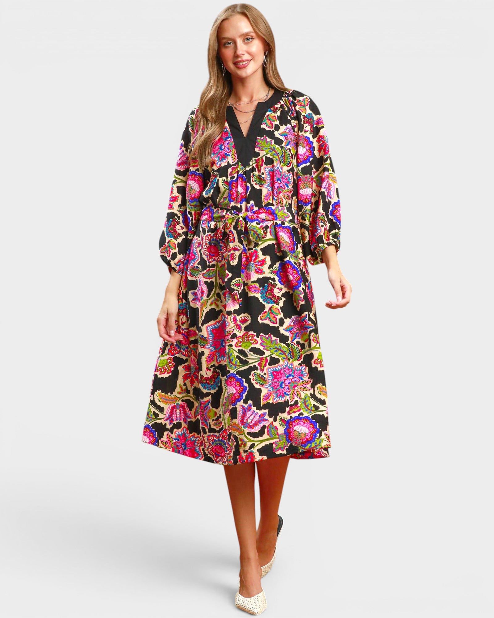 Woman wearing a colorful floral dress on a white background